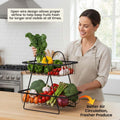 GoHooked black metal 2-tier fruit basket with open wire design, holding fresh produce like kale, peppers, tomatoes, garlic, broccoli, and asparagus.