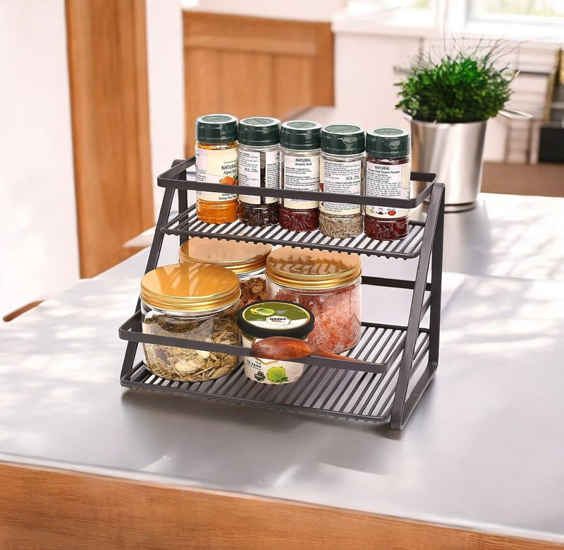 GoHooked 2-tier black metal spice rack organizer with jars and spice bottles on a countertop.