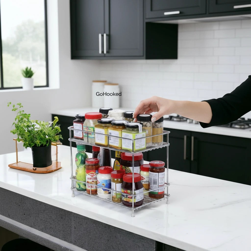 GoHooked 2-tier stainless steel spice rack organizer filled with jars and bottles on a kitchen counter.