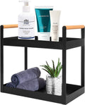GoHooked black metal 2-tier standing rack with wood handles, holding skincare products and towels.