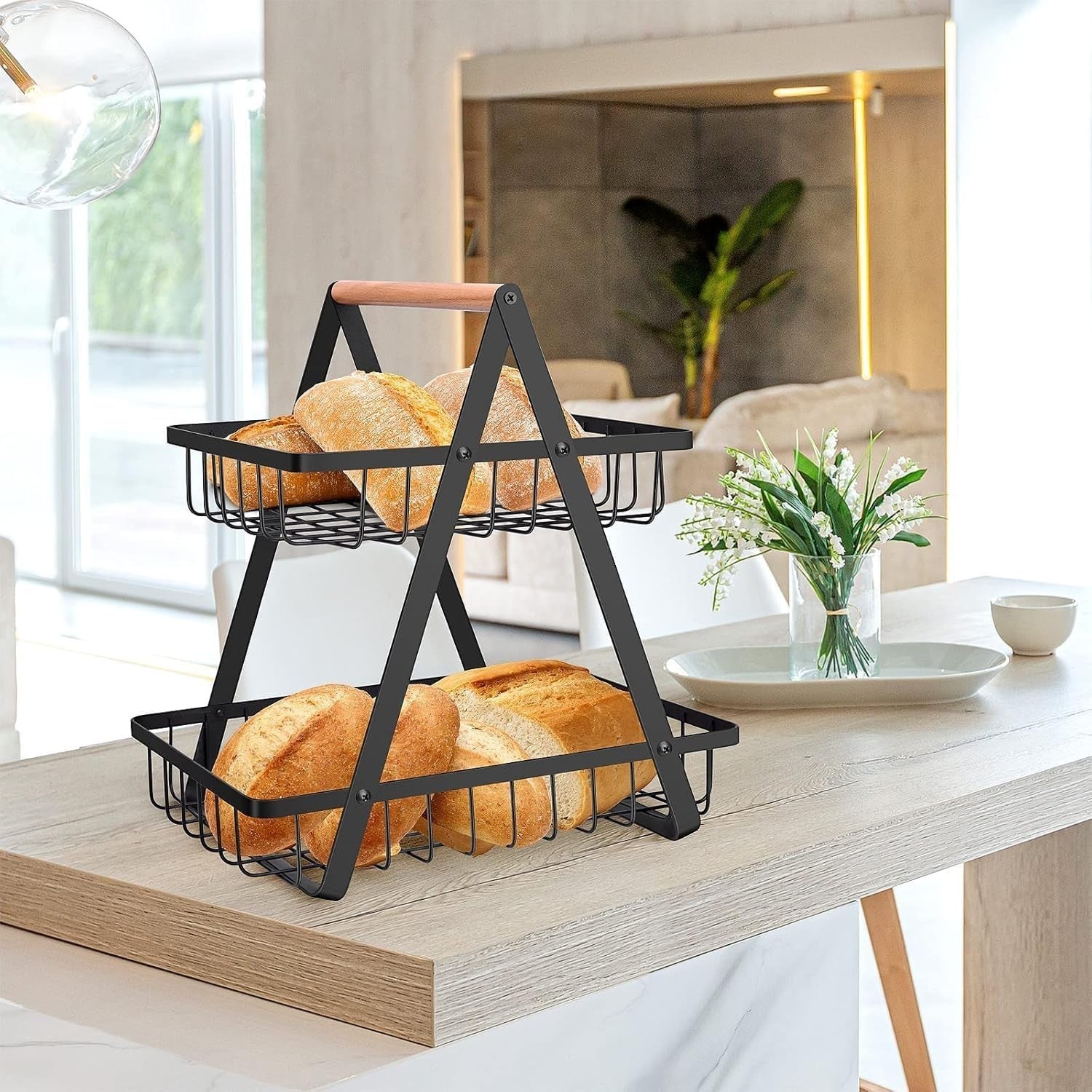 GoHooked black metal 2-tier storage basket with bamboo handle, holding bread on a wooden table.