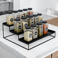 GoHooked 3-tier black metal spice rack organizer filled with spice jars on a countertop.