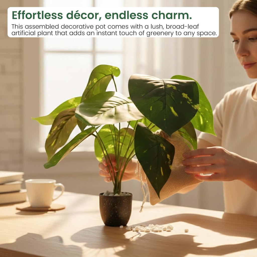 GoHooked artificial Alocasia plant with broad green leaves in a decorative pot being arranged by a woman indoors.