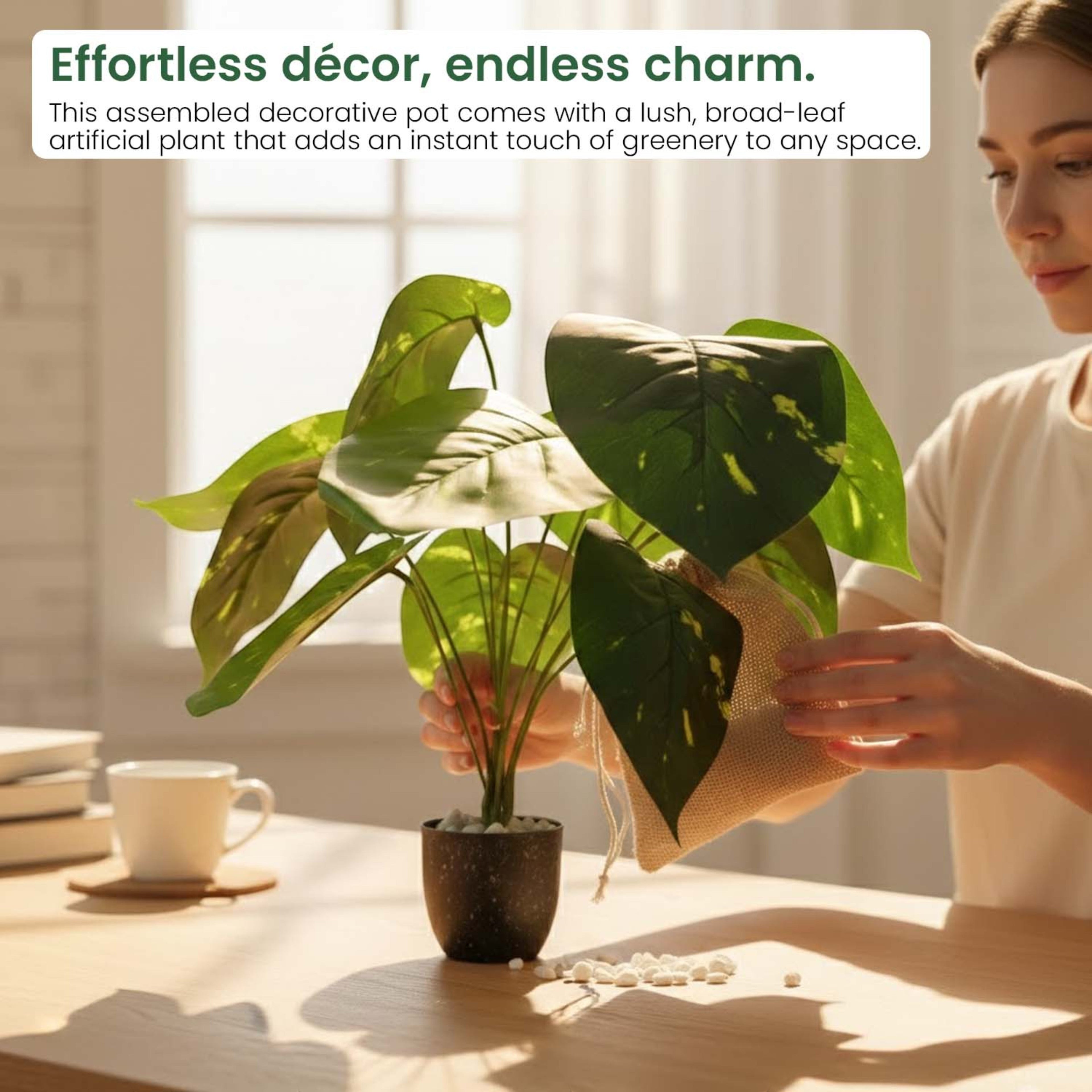 GoHooked artificial Alocasia plant with broad green leaves in a decorative pot being arranged by a woman indoors.