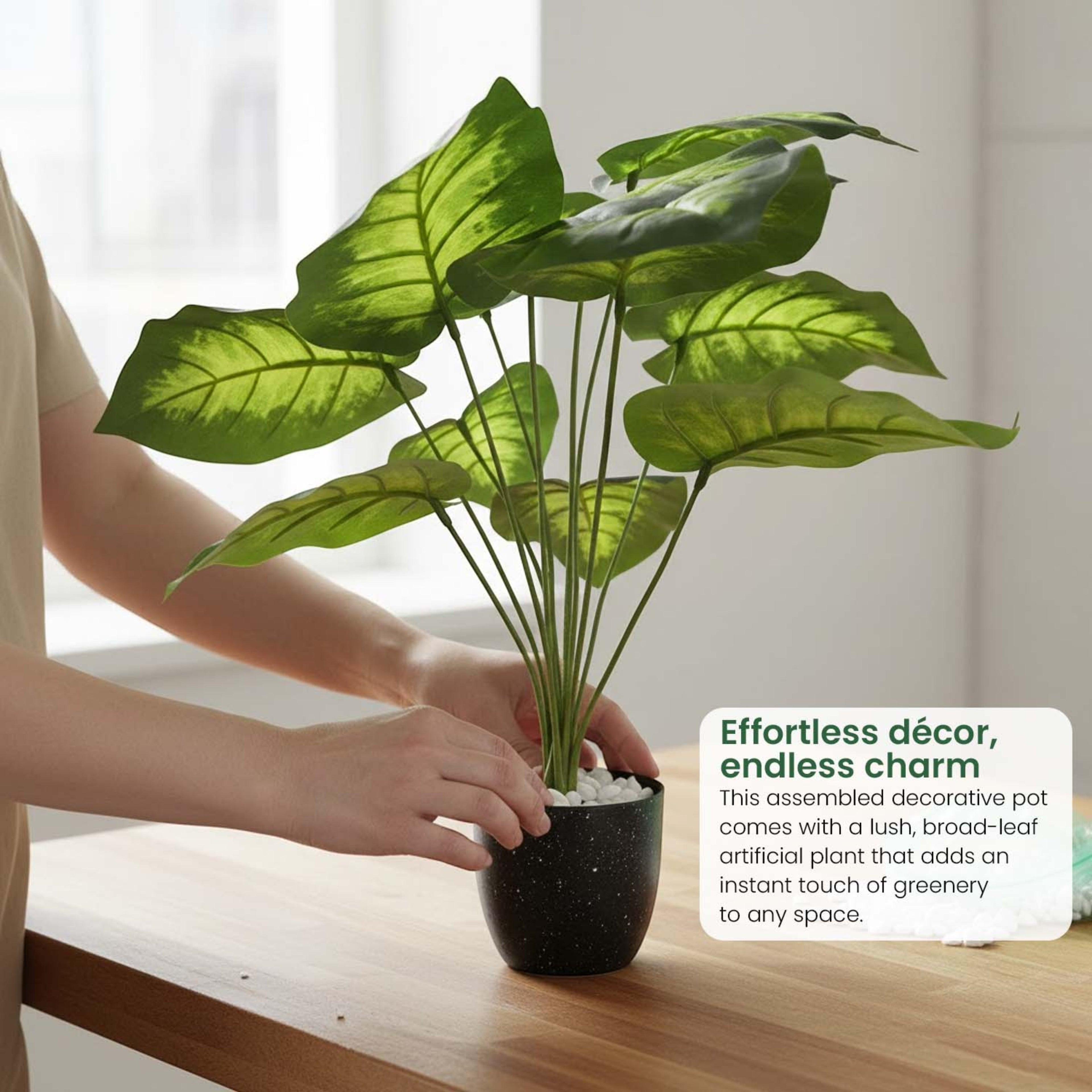 GoHooked artificial Alocasia plant with green patterned leaves in a black speckled pot on a wooden desk
