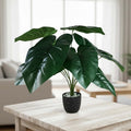 GoHooked artificial Alocasia plant with dark green leaves in a black speckled pot with decorative white pebbles.