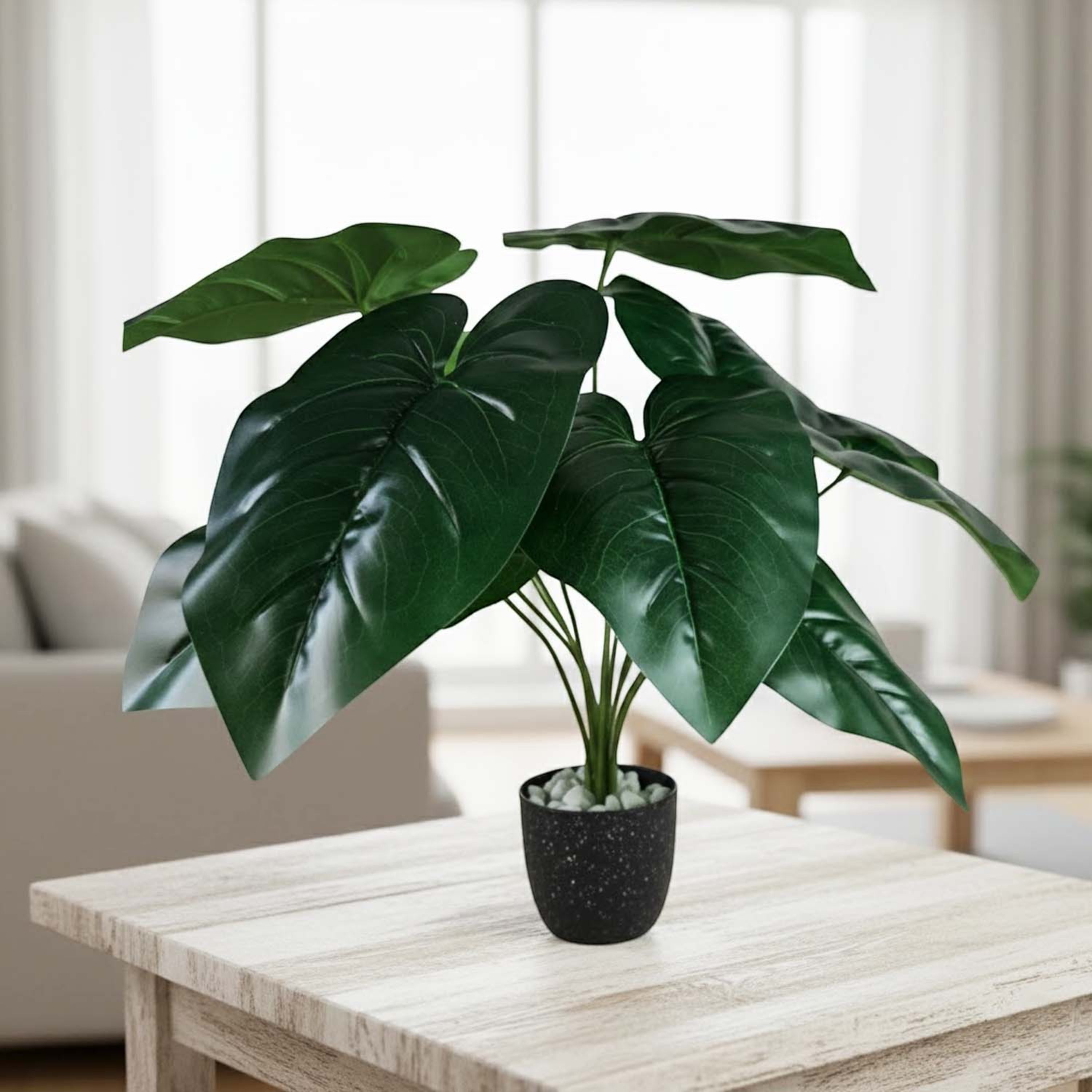 GoHooked artificial Alocasia plant with dark green leaves in a black speckled pot with decorative white pebbles.