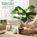 GoHooked artificial Alocasia plant in a black pot with white pebbles, featuring lush green leaves on a wooden desk.