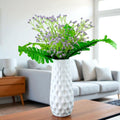 Go Hooked artificial purple baby's breath flowers with green leaves in a white textured vase, realistic rubber and plastic construction.