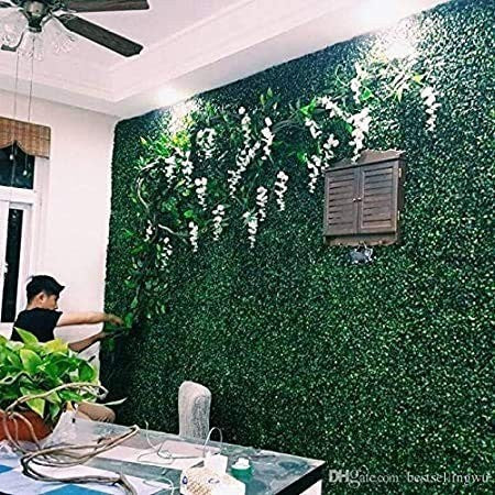 GoHooked artificial boxwood hedge grass tiles create a lush green wall with white flowers, ideal for outdoor or indoor decor.
