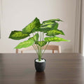 GoHooked artificial Dieffenbachia plant with patterned green leaves in a black speckled pot with white decorative pebbles.