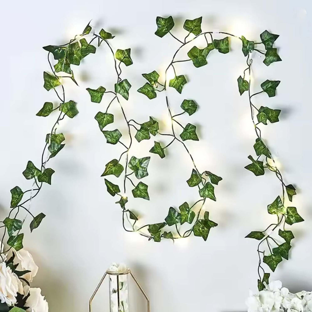 GoHooked artificial green ivy leaf garland with warm white fairy lights, 7 ft long, plastic, for home decor.