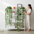 GoHooked Maple Green artificial ivy vines with realistic leaves, draped on a white shelf unit with a woman arranging them.