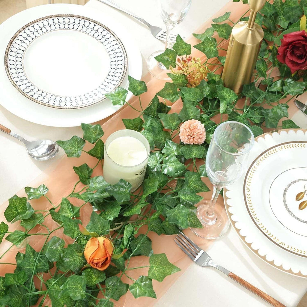 Go Hooked artificial maple leaf creeper garland, 6 ft, green plastic leaves, draped on a table setting with plates, cutlery, and a candle.