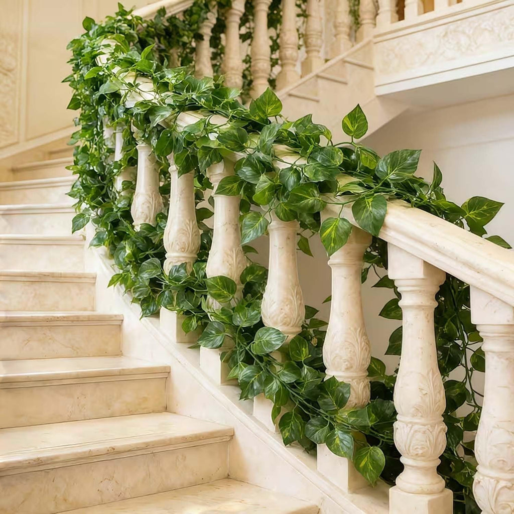 Go Hooked artificial money plant creeper garland with green leaves, draped on a marble staircase railing.