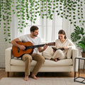 GoHooked artificial money plant leaf garland hanging over a couple sitting on a white sofa in a bright living room