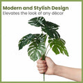 GoHooked artificial Monstera plant with 12 green leaves, held in a hand, perfect for interior decor.
