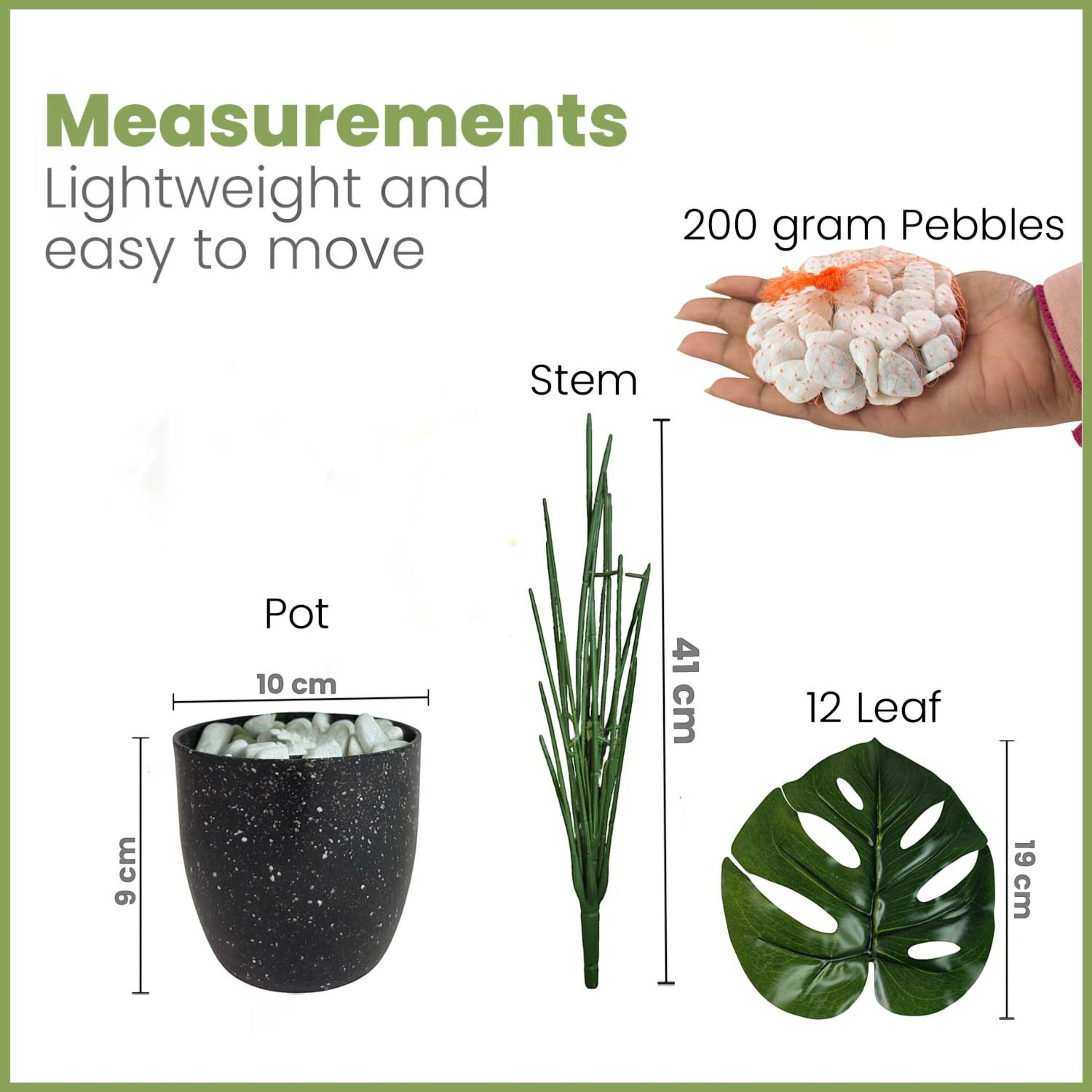 GoHooked artificial monstera plant kit with black speckled pot, green stem, 12 leaves, and decorative white pebbles.