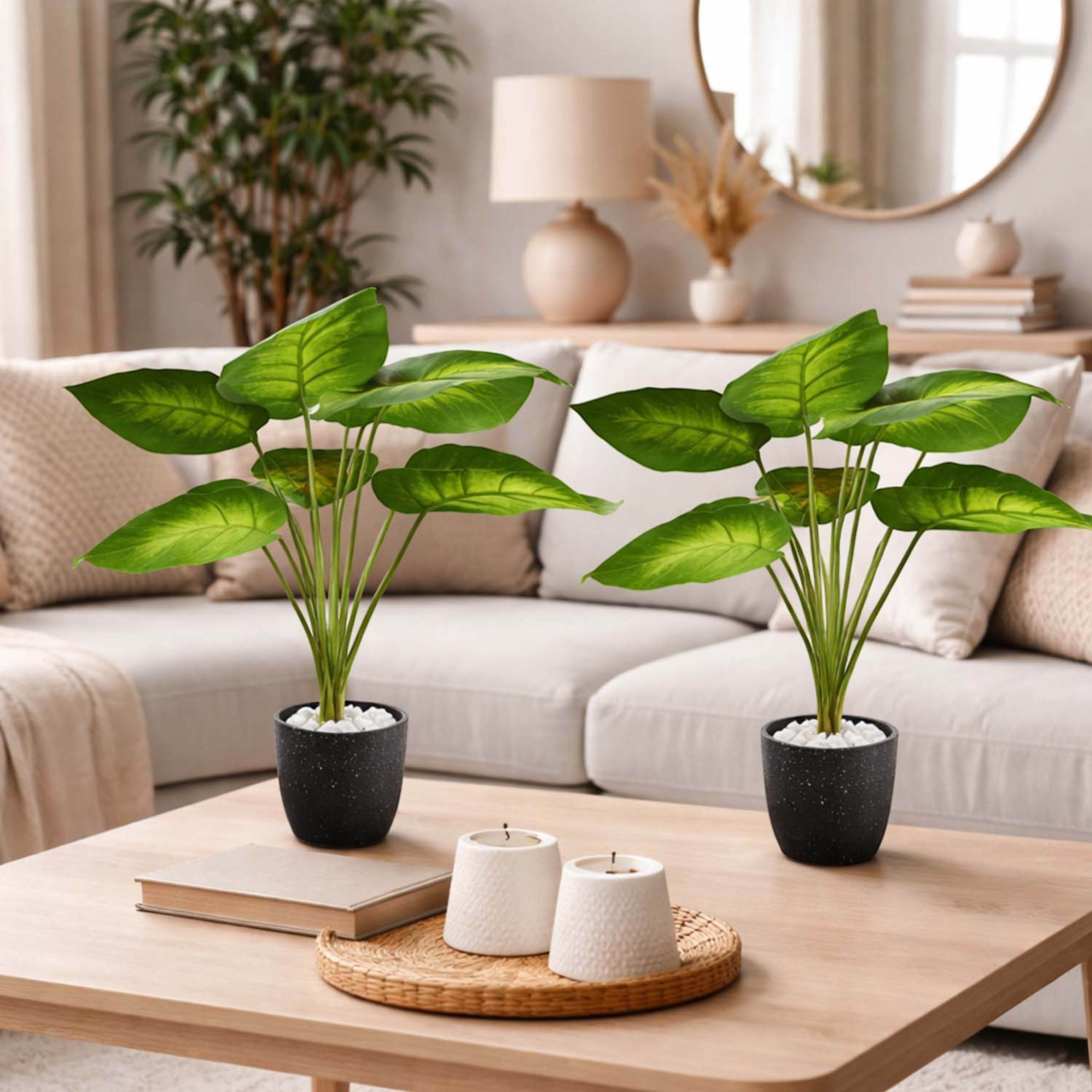 Two GoHooked artificial green potted plants with patterned leaves on a wooden coffee table in a living room.