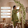 Go Hooked artificial watermelon peperomia creeper garland with green leaves and fairy lights, draped by a woman indoors.