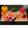Go Hooked bamboo cutting board with a knife, carrots, beet, bell peppers, and tomato. Sliced carrots are on the board.