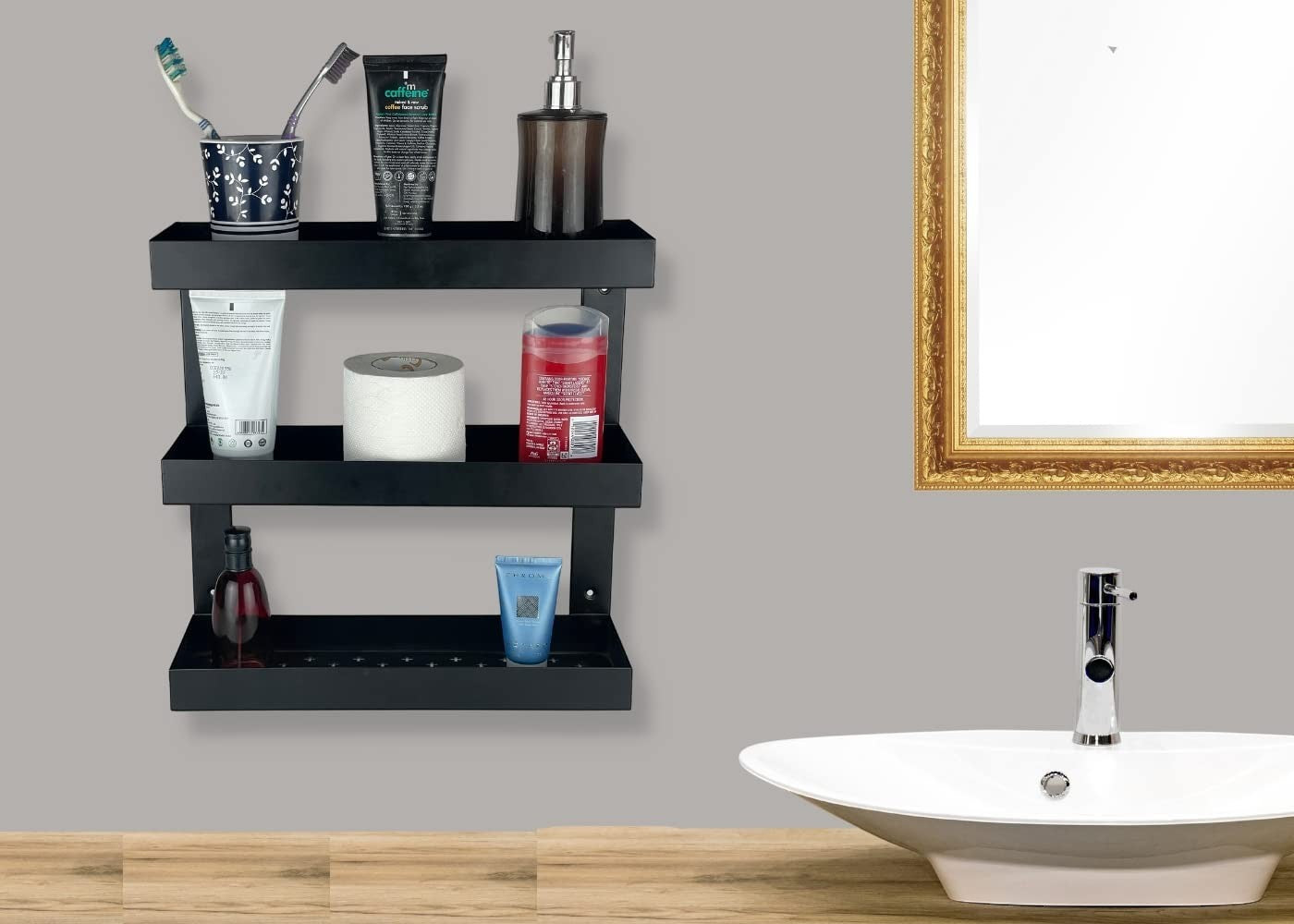 GoHooked Bianco black metal 3-tier bathroom shelf rack holding toiletries, toilet paper, and soap dispenser.