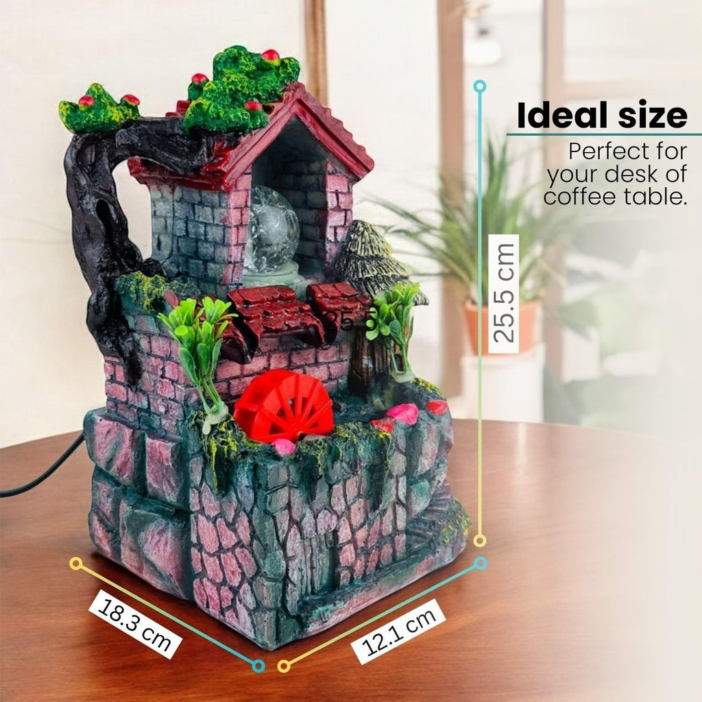 GoHooked BIANCO polyresin tabletop waterfall fountain with LED lights and red water wheel. Multicolour brick design with green foliage.