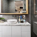 Go Hooked black 2-tier metal vanity rack organizer holding various bathroom products on a countertop.