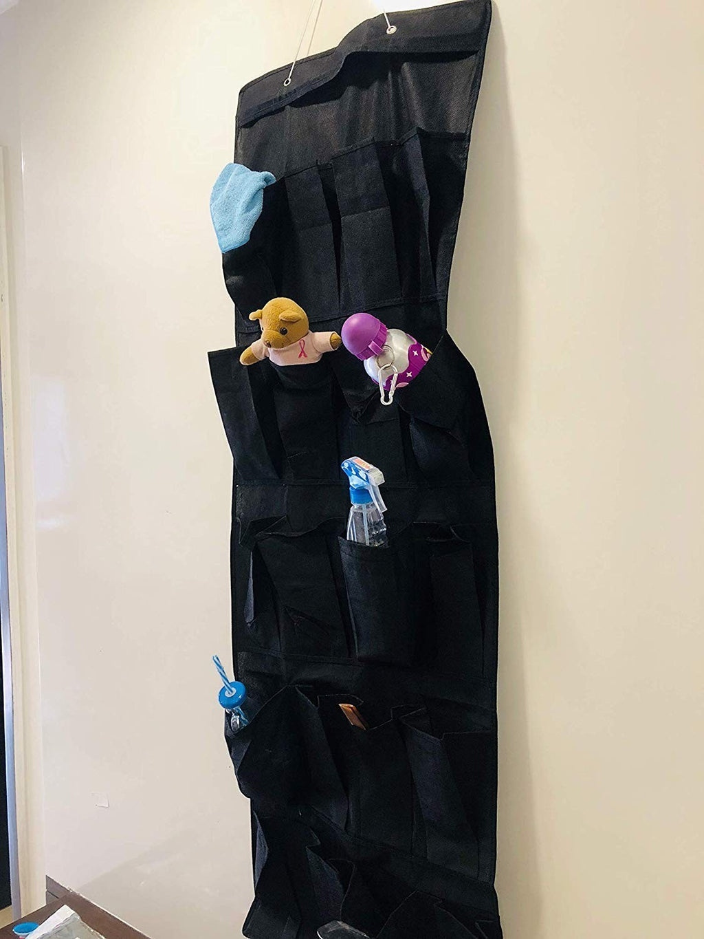Go Hooked black 20-pocket over-the-door organizer made of non-woven fabric, holding toiletries, toys, and cleaning supplies.