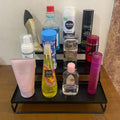 GoHooked black 3-tier metal step rack organizer holding various personal care and beauty products.