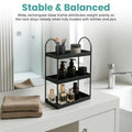 Go Hooked black 3-tier curved metal vanity organizer with bottles, jars, and brushes on a bathroom counter.