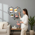 GoHooked black metal heart-shaped photo grid with shelf, displaying photos and decorative flamingos.