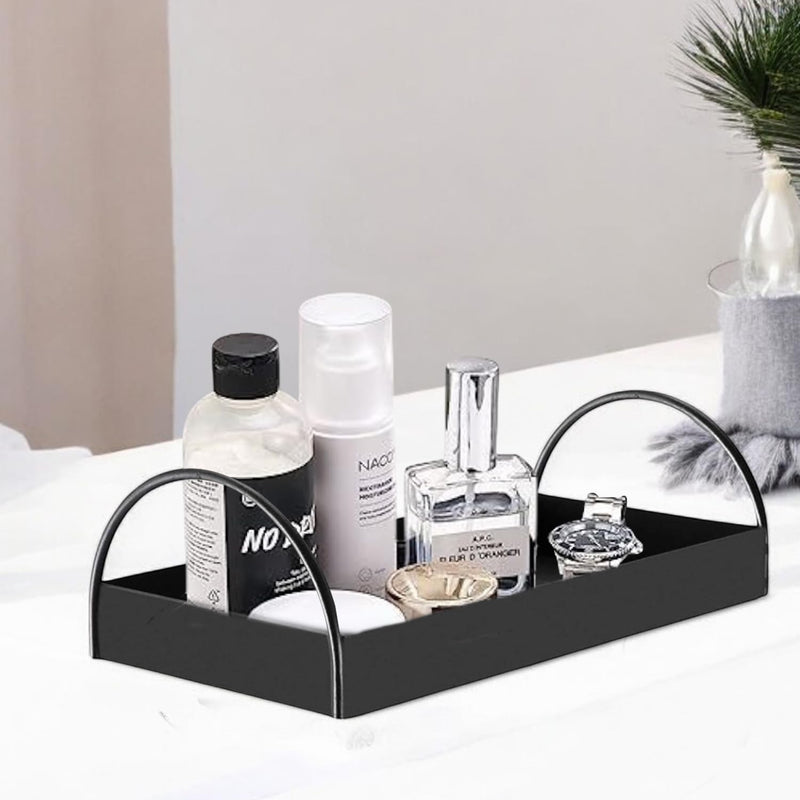 Go Hooked black iron vanity tray with arched handles, holding perfumes, lotions, and a watch.