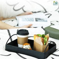 Go Hooked black iron vanity tray with handles, holding a coffee cup, sandwich, and cookie on a bed.