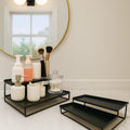 Go Hooked black metal 2-tier standing organizer with bathroom essentials like soap, cotton swabs, and makeup brushes.