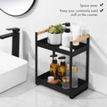 GoHooked black metal 2-tier standing rack with wood handles, holding bathroom toiletries and cosmetics.