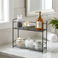 GoHooked black metal 2-tier wire rack organizer holding bathroom essentials like soap, bath salts, and cotton balls.