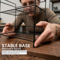 GoHooked black metal 2-tier wire rack organizer on a wooden countertop, ideal for spices and bottles.