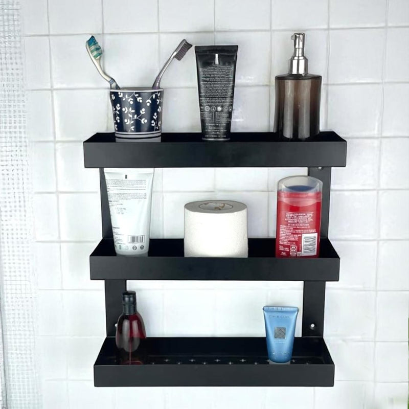 GoHooked black metal 3-tier bathroom shelf rack holding toiletries, toothpaste, and soap dispenser.
