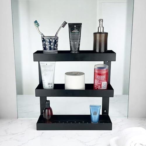 GoHooked black metal 3-tier bathroom shelf rack holding toiletries, toothpaste, and soap dispenser.