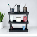 GoHooked black metal 3-tier bathroom shelf rack holding toiletries, toothpaste, soap dispenser, and toilet paper.