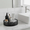 GoHooked black metal revolving bathroom organizer tray with grid pattern, holding toiletries and skincare.