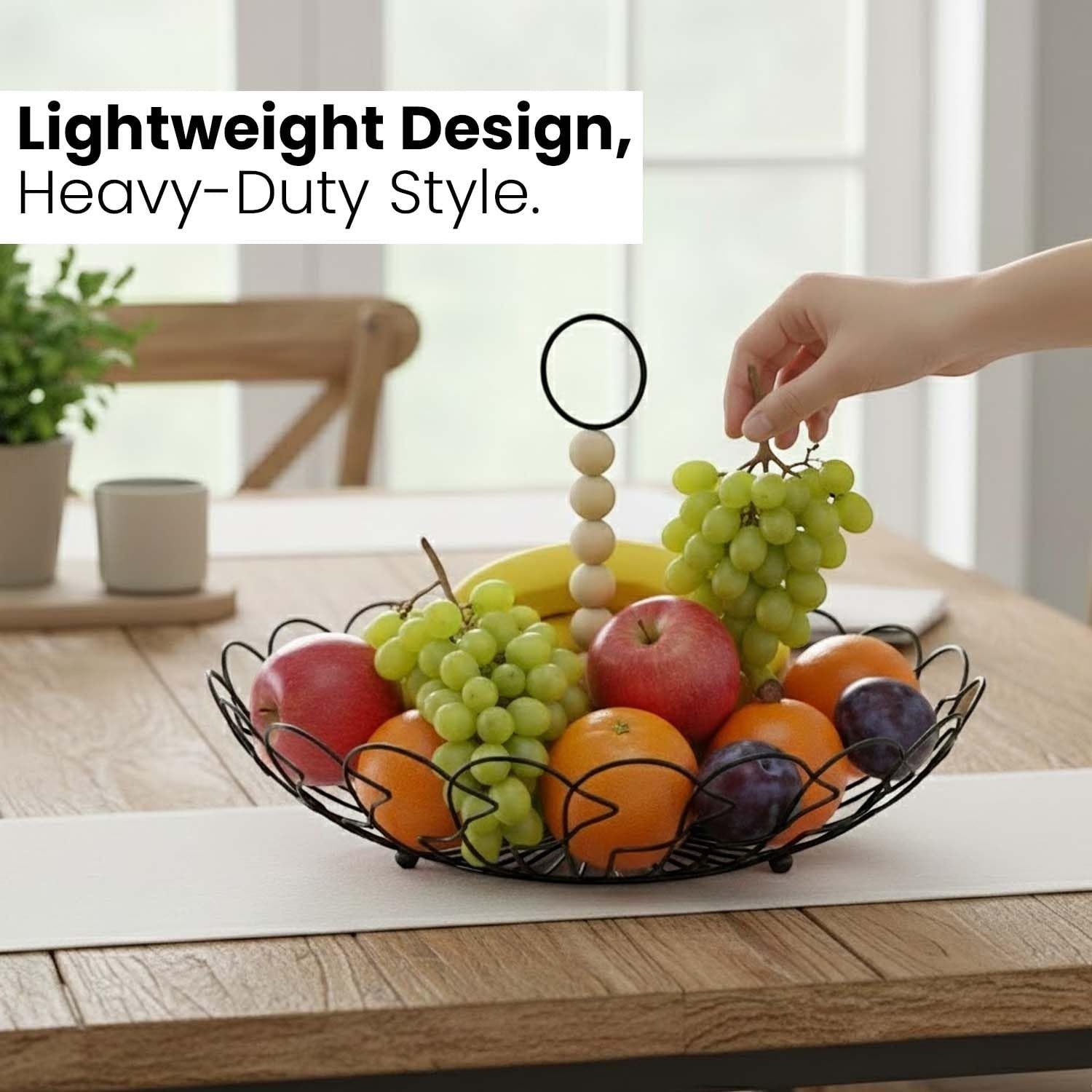 GoHooked black metal wire fruit basket with detachable wooden handle, filled with apples, oranges, grapes, and plums.