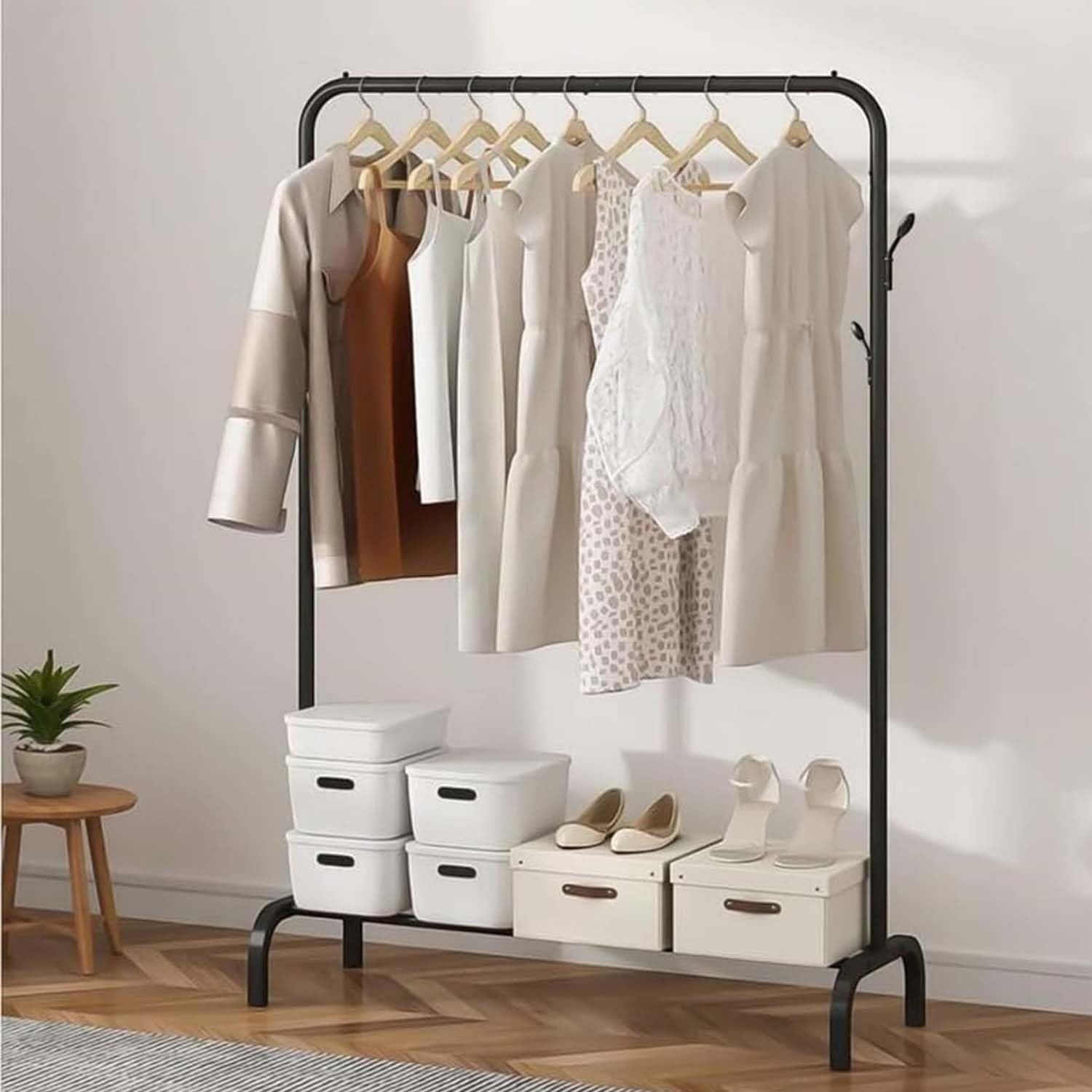 Go Hooked black metal garment rack with 8 side hooks and bottom shelf, holding clothes and shoes.