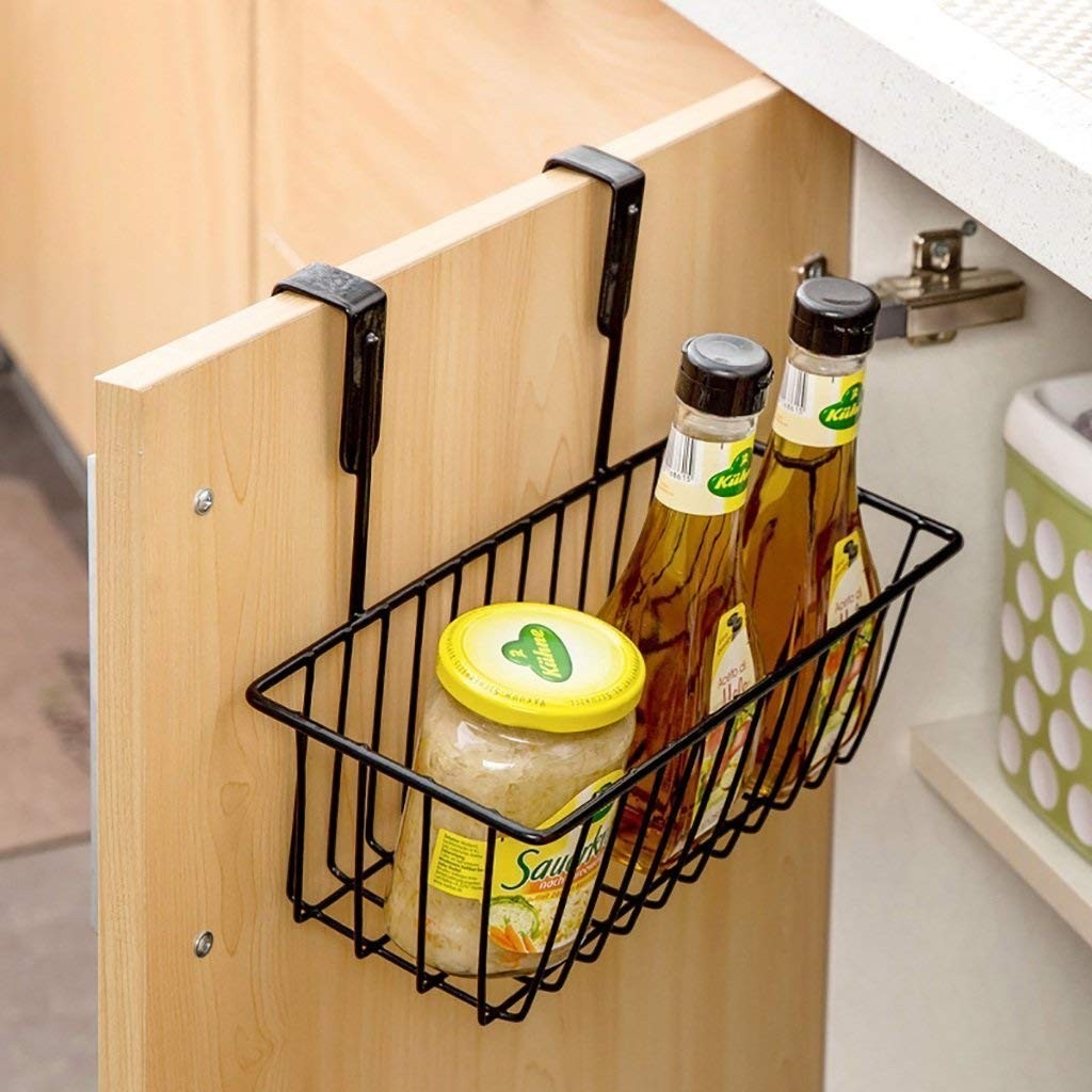 GoHooked black metal over door hanging basket with two bottles of oil and a jar of sauerkraut.