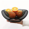 GoHooked black double-layer metal mesh fruit bowl with oranges and sliced oranges.