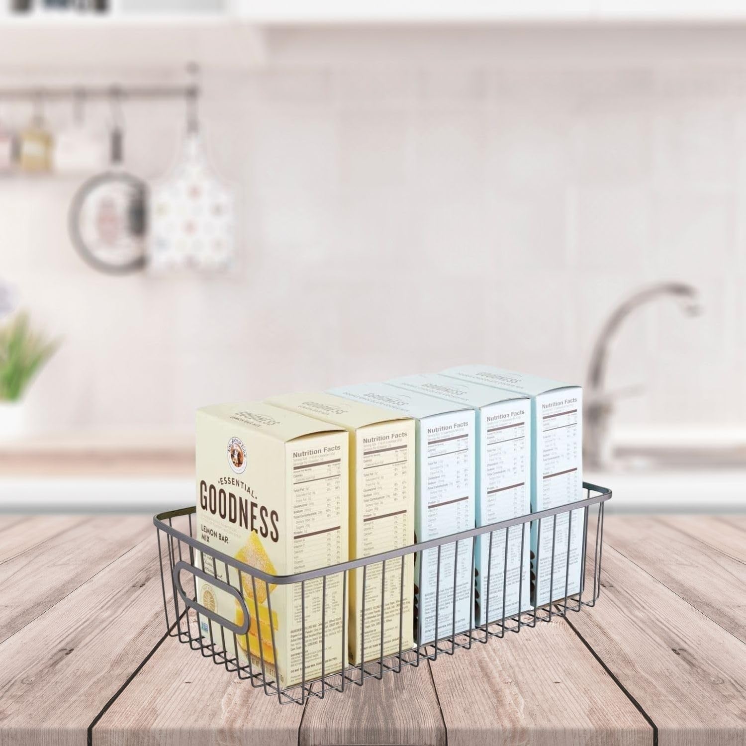 GoHooked black metal farmhouse pantry basket with wire grid design and handles, holding boxes of food.