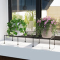 GoHooked black metal rectangular plant stand holding two potted plants on a windowsill.