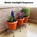 GoHooked black metal rectangular plant stand holding three potted plants on a balcony.
