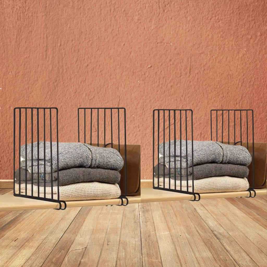Go Hooked black metal shelf dividers organize stacks of folded sweaters and blankets on a wooden shelf.